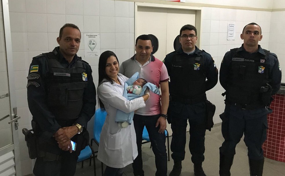 Policiais que participaram do resgate acompanham bebê após receber os primeiros cuidados (Foto: PM/SE)