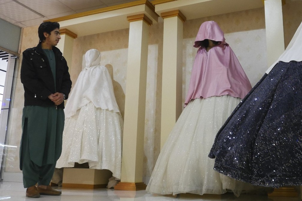 Lojista observa manequins com cabeças cobertas em Herat. Apenas cobrir a cabeça dos bonecos não é suficiente para o Talibã, que pede que elas sejam retiradas — Foto: AFP
