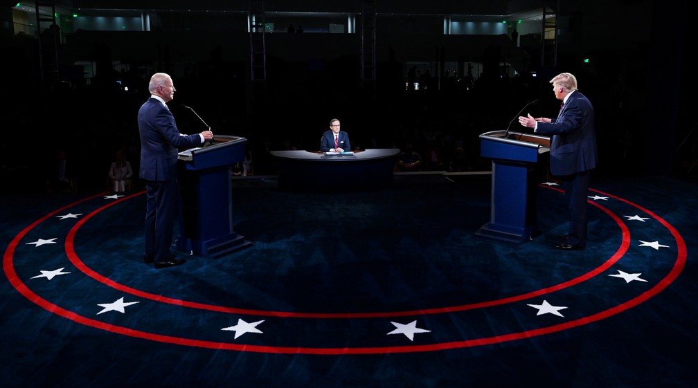 Observados pelo moderador Chris Wallace, Donald Trump e Joe Biden participam de debate presidencial em Cleveland, Ohio, na terça-feira (29). — Foto: Olivier Douliery/Pool via REUTERS
