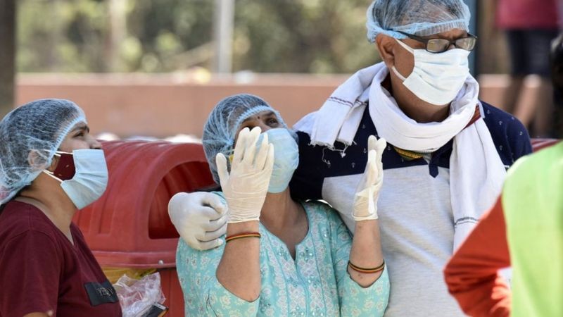 Equipe médica lamentando mortes por coronavírus em Kuvadava, uma vila em Gujarat (Foto: Getty Images)