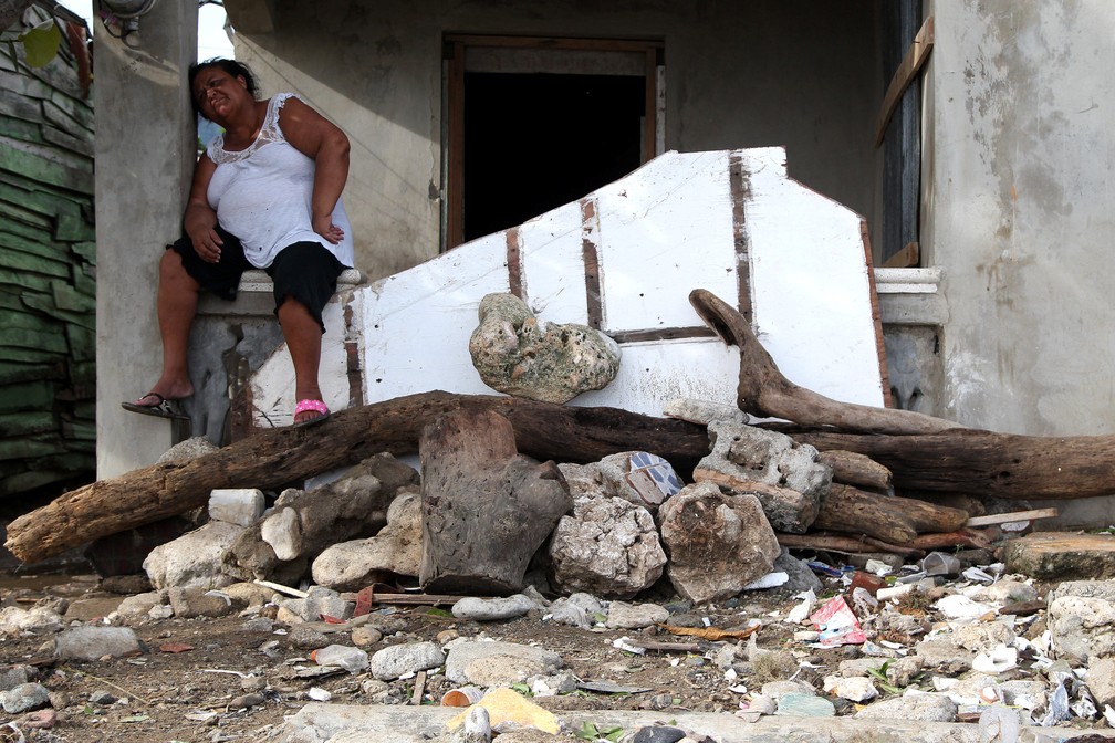 Mulher descansa antes de voltar a retirar os escombros de casa que caiu com a passagem do furacão Irma pelo Haiti. (Foto: Ricardo Rojas/Reuters)