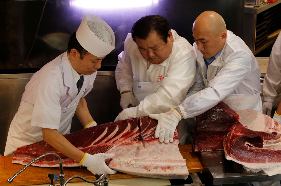O presidente da Kiyomura Co, Kiyoshi Kimura (ao centro), que controla a rede de restaurantes japonesa Sushi Zanmai, corta um atum de 278 kg que ele arrematou por US$ 3,1 milhões em leilão no mercado de Toyosu, em Tóquio, neste sábado (5); valor superou recorde de 2013 — Foto: Kim Kyung-Hoon/Reuters
