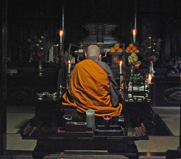 Um monge budista da escola Shingon medita na escuridão, iluminado apenas por velas em uma das salas do templo Rengejo-in, um dos 52 templos do monte Koya, no Japão