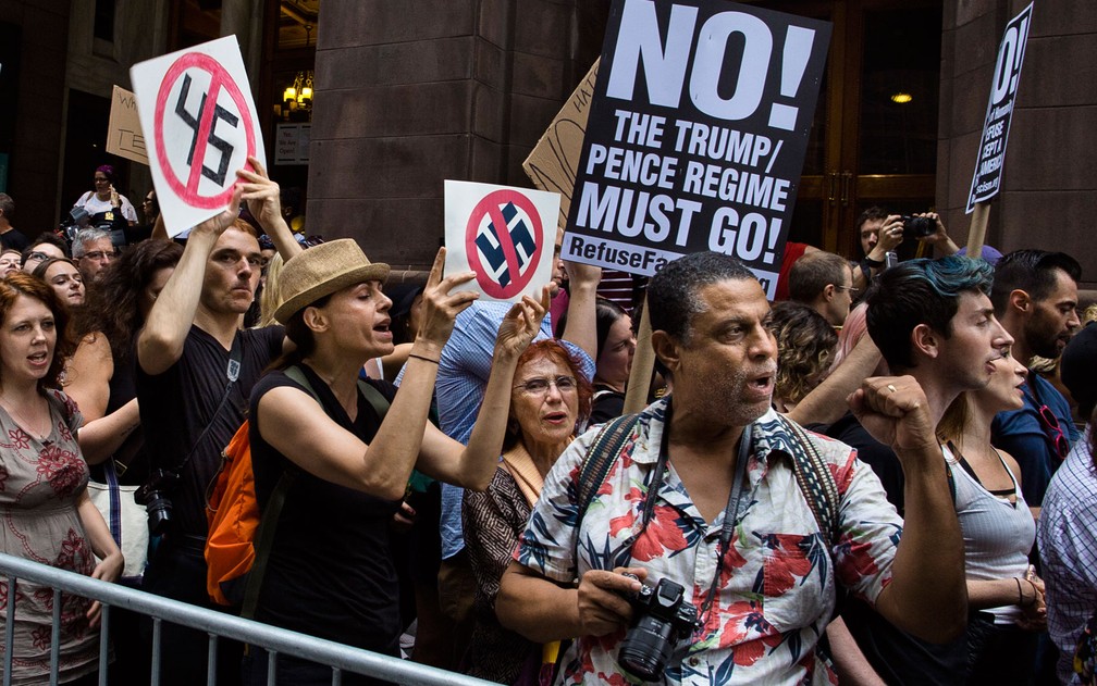 Manifestantes exibem cartazes contra movimento nazistas e de supremacistas brancos do lado de fora da Trump Tower, em Nova York, na segunda (14) (Foto: AP Photo/Andres Kudacki)