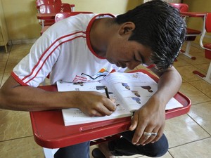 Aluno conta que aprendeu a escrever o próprio nome após entrar na escola, em Itumbiara, Goiás (Foto: Adriano Zago/G1)