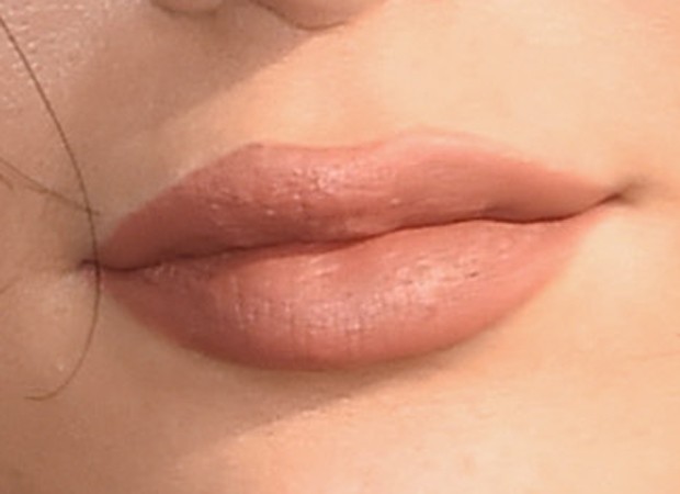 Zoom no bocão de Kylie; é possível ver que o batom passa da linha natural dos lábios da patricinha (Foto: Getty Images)