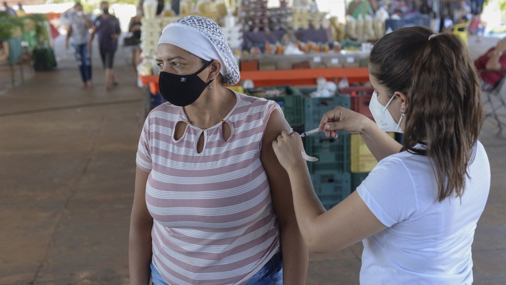 Feirante sendo vacinada na feira da quadra 503 Norte — Foto: Raiza Milhomem/Prefeitura de Palmas