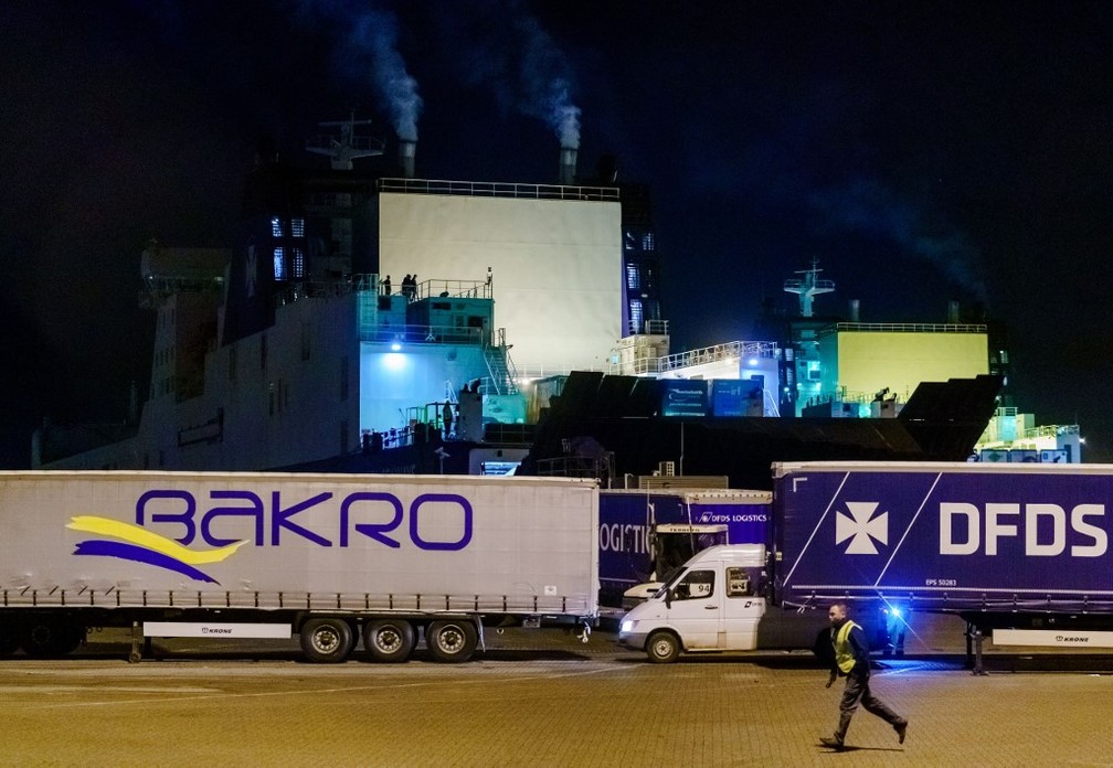 Navio, ao fundo, foi encontrado com 25 pessoas viajando escondida da Holanda para o Reino Unido nesta terça-feira (19) — Foto: Marco de Swart/ANP/AFP