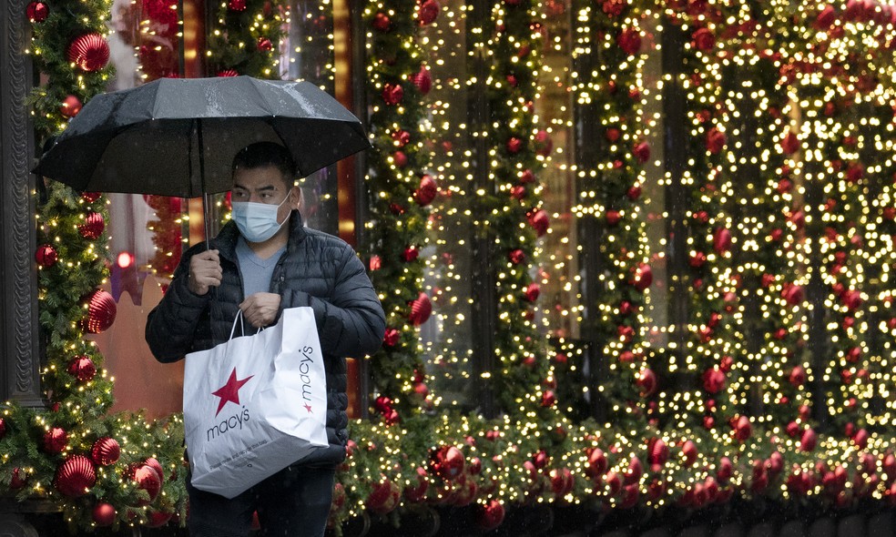 Homem carrega sacola em zona de compras em Nova York no início da temporada de Natal nos EUA em meio a pandemia de Covid-19, em foto de 30 de novembro de 2020 — Foto: Mark Lennihan/AP/Arquivo