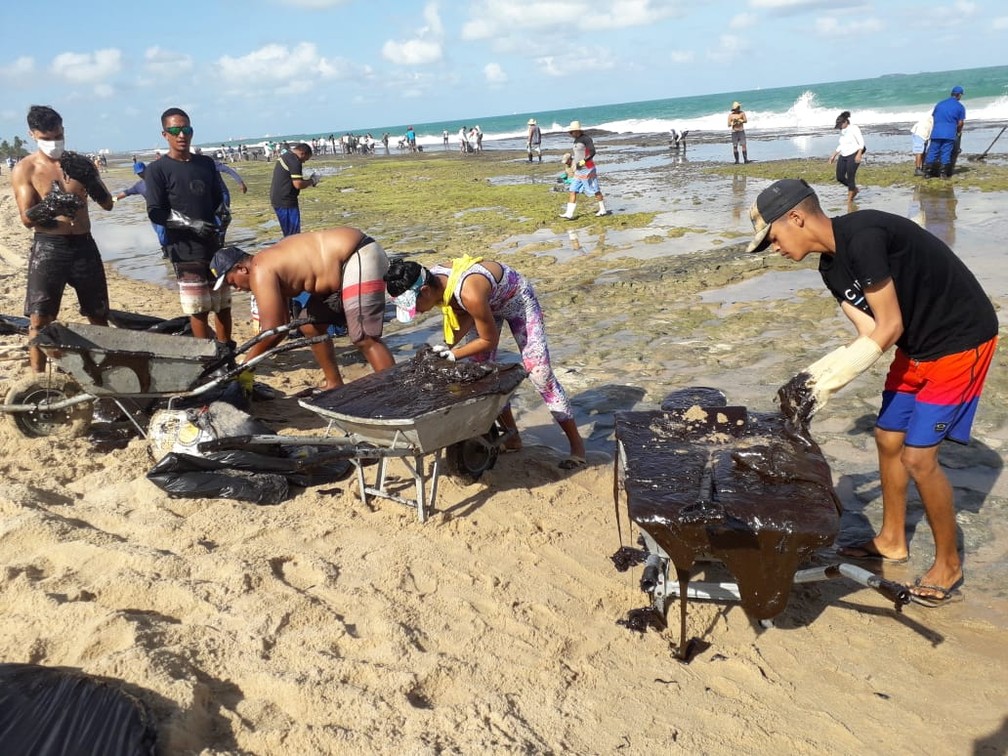 Voluntários retiram óleo de arrecife na praia de Muro Alto, em Ipojuca — Foto: Luna Markman