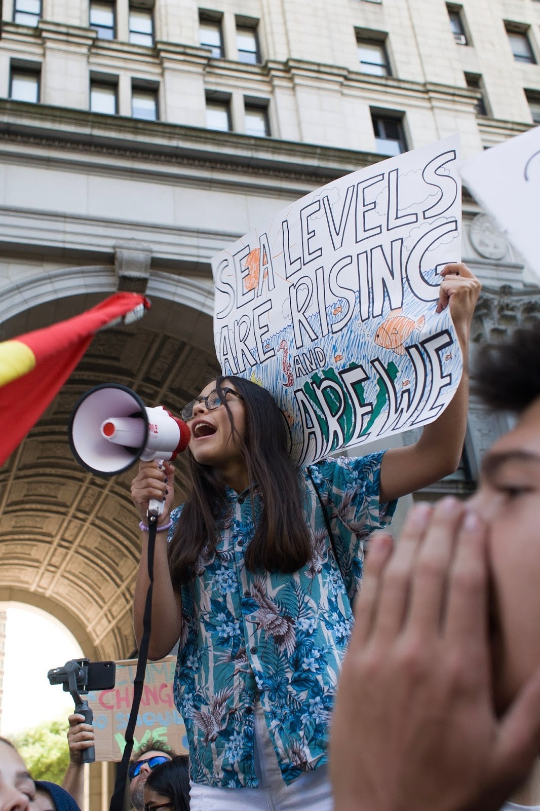 Jovem ativista levanta cartaz que diz “Os niveis do mar estão se levantando e nos também” (Foto: Bruna Scorsatto)