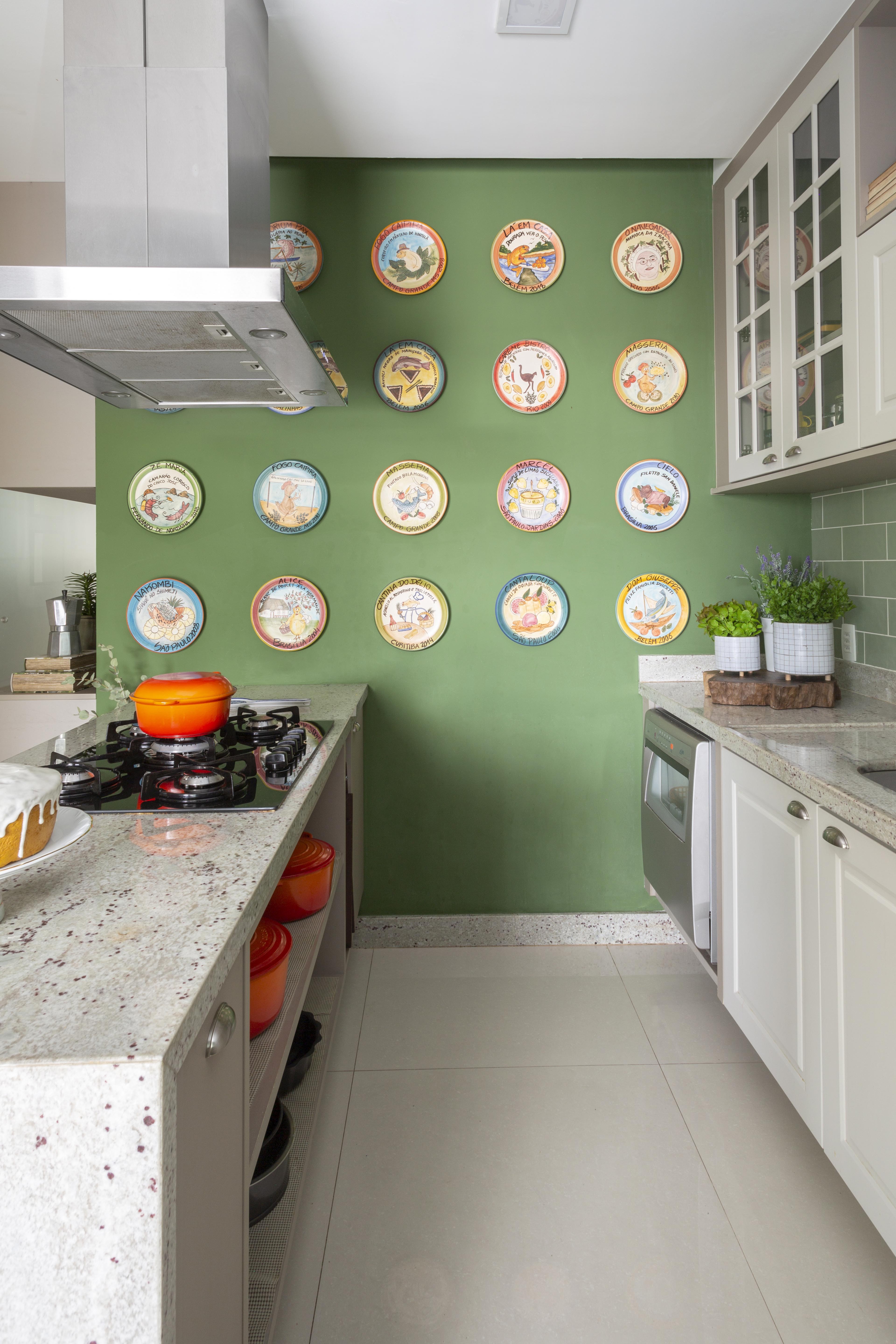Cozinha verde pistache com pratos pendurados na parede