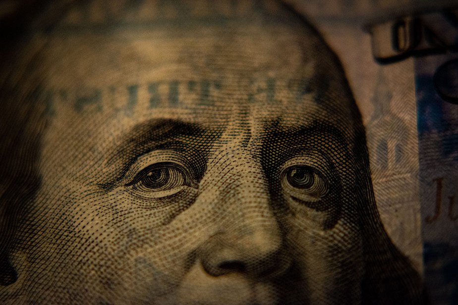Dinheiro: close-up de uma nota de 100 dólares, focando o rosto de Benjamin Franklin.