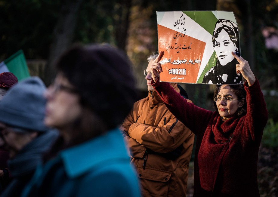 Mulher protesta contra o regime do Irã em frente à Câmara dos Representantes em Haia