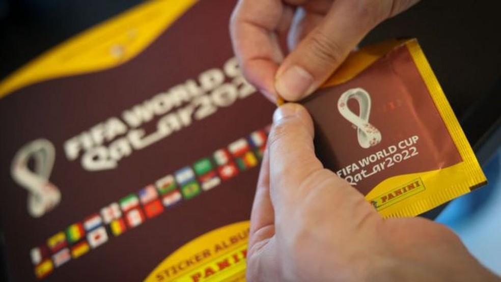 Pessoa abre um envelope de figurinhas para a Copa do Mundo de 2022 — Foto: GETTY IMAGES/via BBC