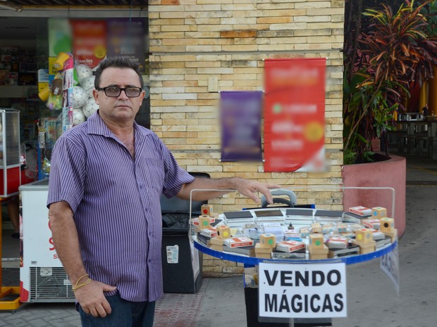 Mágico Sobral vende mágica na orla de João Pessoa com placa vende-se mágica (Foto: Dani Fechine/G1)