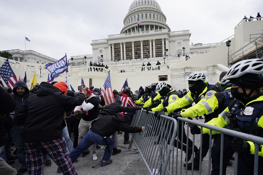 Apoiadores de Trump forçam grades em frente ao Capitólio, prédio do Congresso americano — Foto: Julio Cortez/AP