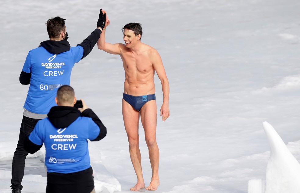 David Vencl comemora depois de bater novo recorde de nado no gelo, após percorrer 81 metros de distância submergido. — Foto: Reuters.