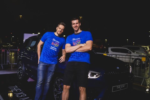 Murilo e Éder, jogadores de vôlei, posam em frente ao X3M no meeting point da BMW