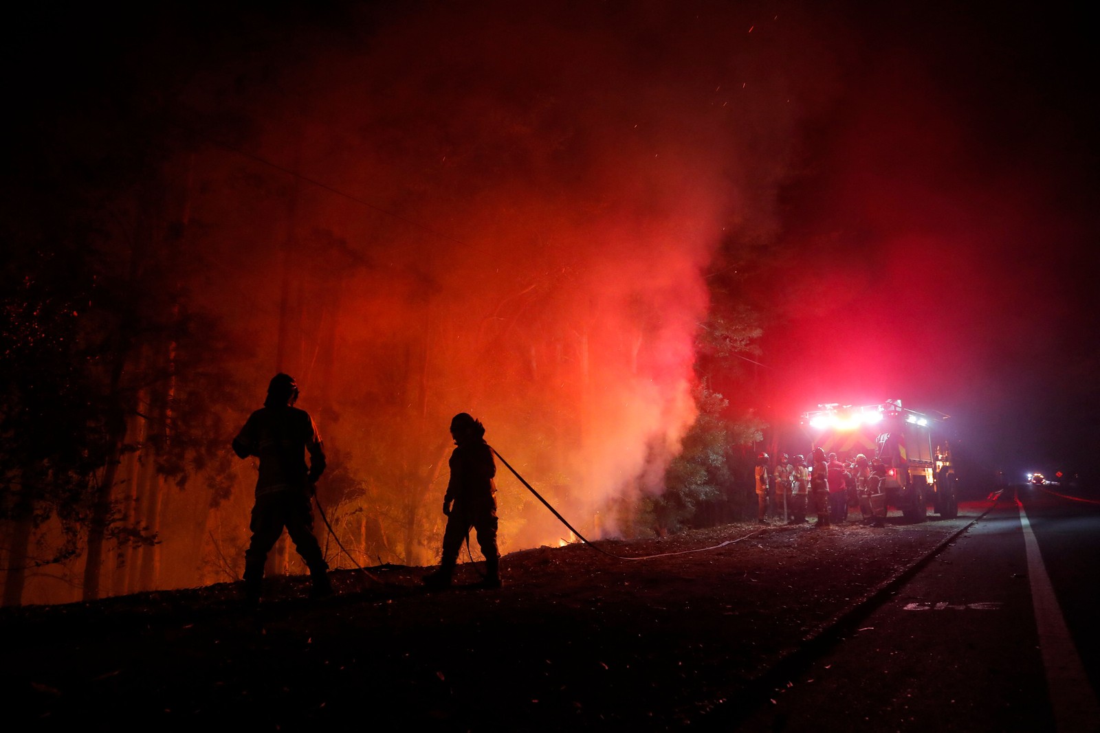 Bombeiros combatem um incêndio florestal em Santa Juana, na província de Concepción, no Chile — Foto: JAVIER TORRES/AFP