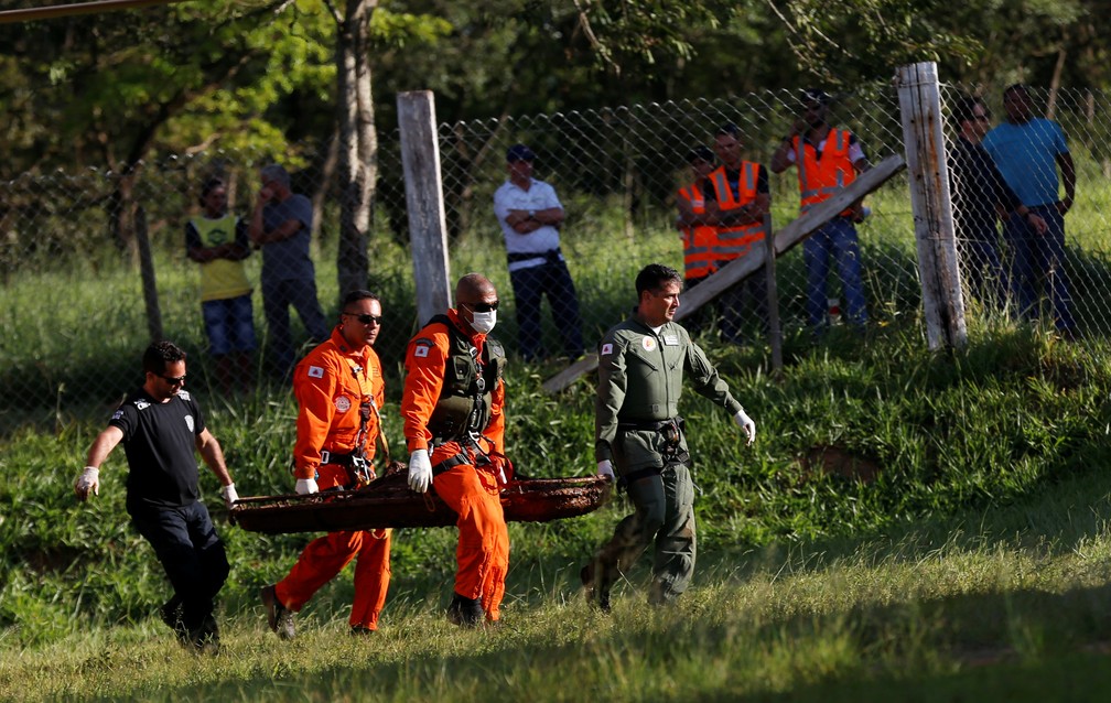 Membros de equipe de resgate carregam corpo retirado da lama dois dias depois do rompimento da barragem da Vale, em Brumadinho. — Foto: Adriano Machado/Reuters