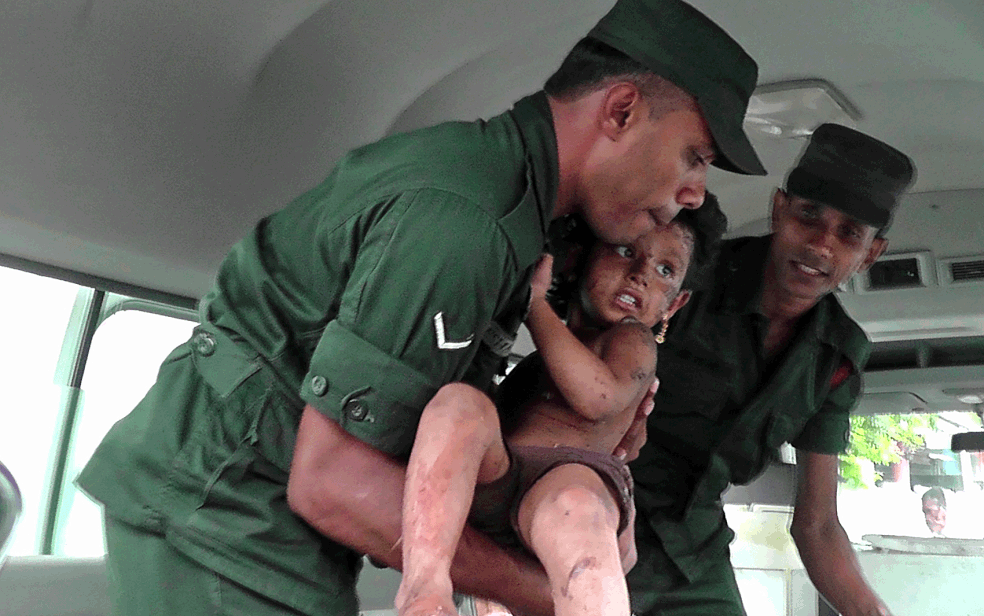 Soldados retiram uma criança após invadirem uma casa que as forças de segurança dizem ser esconderijo de integrantes do Estado Islâmico — Foto: Stringer / AFP Photo