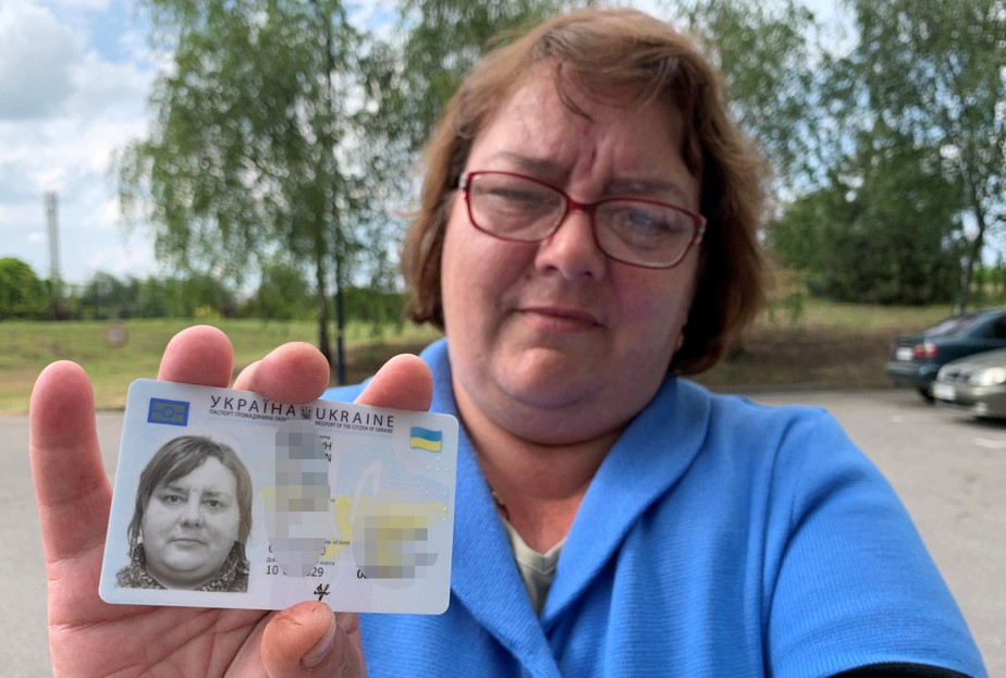 Victoria, de 43 anos, segura sua carteira de identidade, o passaporte interno ucraniano, em Zaporizhzhia
