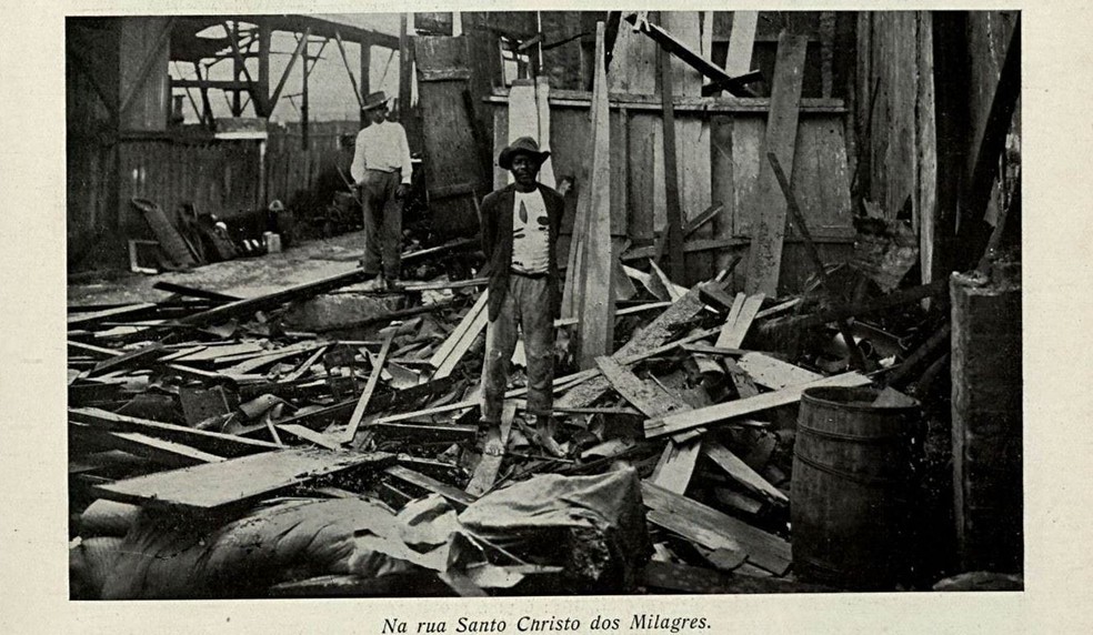 Homens em casa destruída pela enchente em 1911 — Foto: Careta/Acervo da Biblioteca Nacional