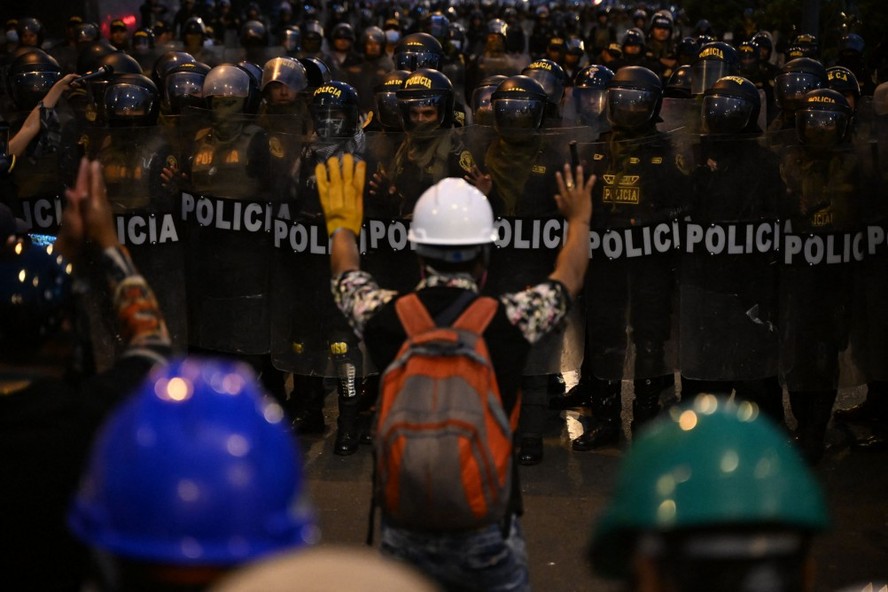 Manifestantes frente a polícia em protesto em Lima no sábado