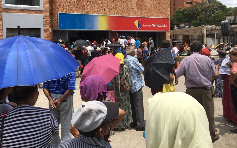 Enormes filas para sacar dinheiro são comuns na Venezuela de hoje — Foto: Guillermo Olmo/BBC News Mundo