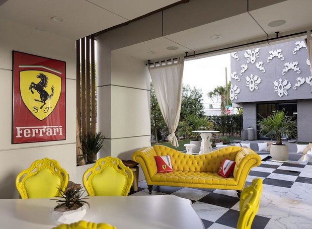 O espaço externo conta com mais uma área externa inspirada na Ferrari, com sofá e cadeiras amarelos (Foto: The Wall Street Journal / Reprodução)