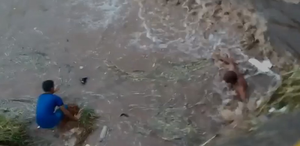 Homem se arrisca para salvar cachorra que estava se afogando em rio durante temporal — Foto: J. Serafim / Divulgação 