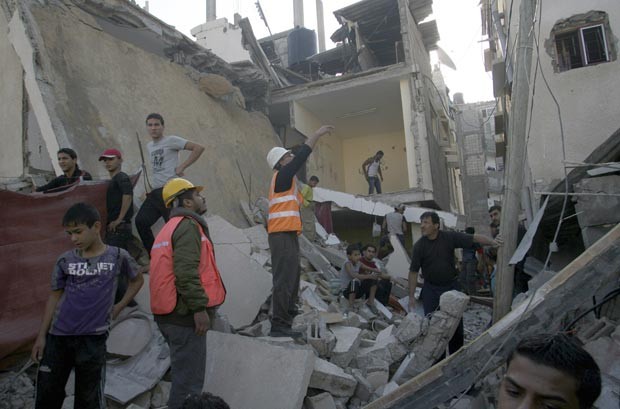 Palestinos observam estragos provocados por bombardeios a casa de militante do Hamas nesta terça-feira (20) em Rafah, na Faixa de Gaza (Foto: AP)