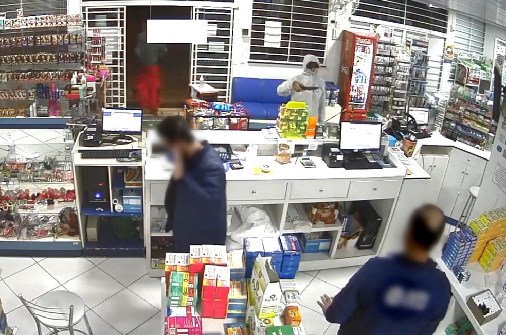 Funcionários de farmácia de Pinhão foram rendidos pelos assaltantes, na noite de segunda-feira (25) — Foto: Câmeras de segurança
