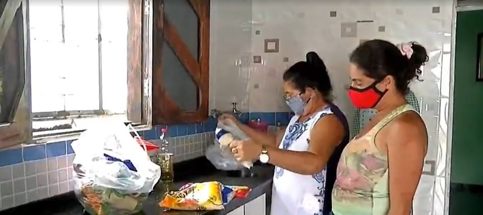 Mesmo sendo sem ter uma renda fixa, Felícia (de blusa branca) abrigou uma família.  — Foto: Reprodução/TVM