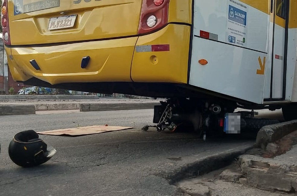 Moto bateu com ônibus na Av. Suburbana. Por causa do impacto, moto foi parar embaixo do ônibus.  — Foto: Cid Vaz / TV Bahia