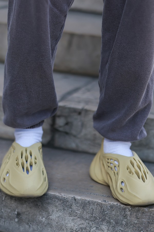 PARIS, FRANCE - JUNE 23: A guest seen wearing a dark grey jogger pants from Urban Outfitters, white socks and beige Adidas Yeezy Foam shoes, outside the Nahmias show, during Paris Fashion Week - Menswear Spring/Summer 2023 on June 23, 2022 in Paris, Franc (Foto: Getty Images)