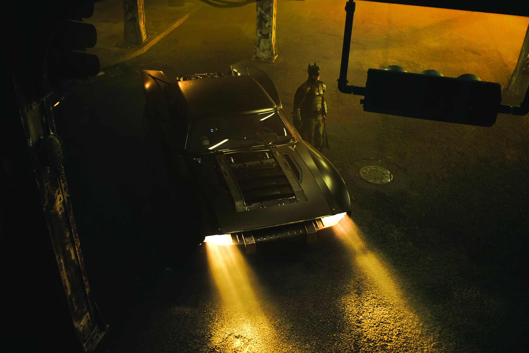 Cena de The Batman (2022) com Robert Pattinson no papel principal ao lado do Batmóvel (Foto: Divulgação)