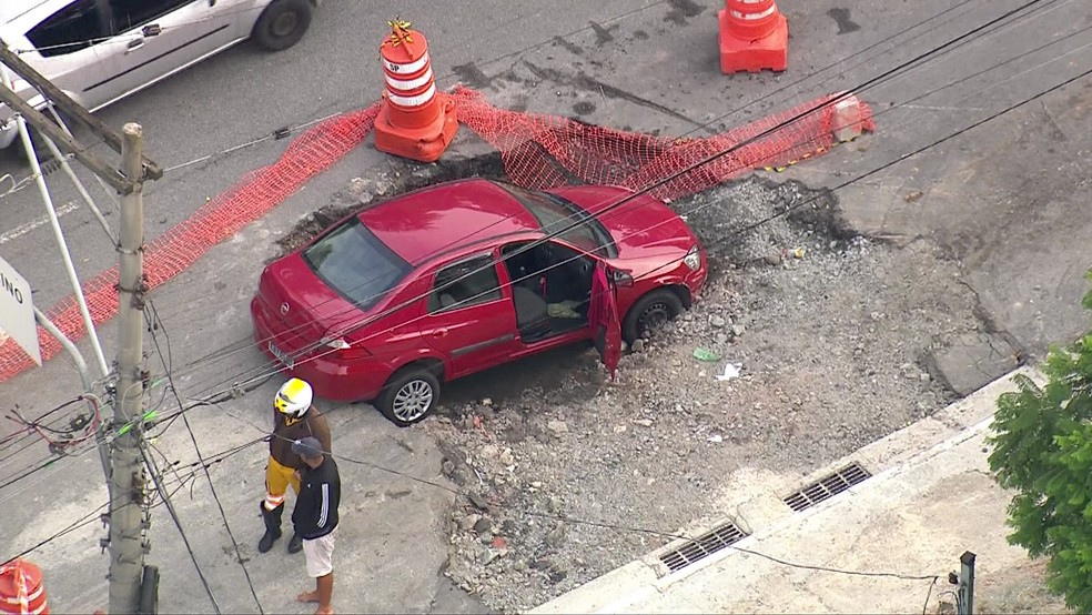 Carro em buraco na Zona Leste — Foto: Reprodução/TV Globo