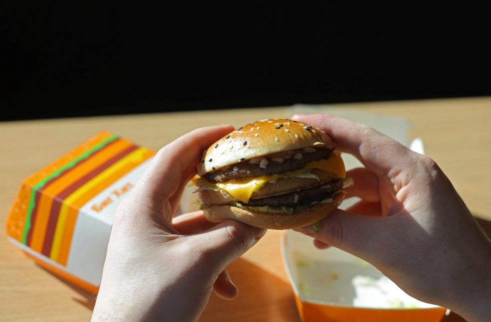 Um homem segura um hambúrguer Big Hit, a nova alternativa ao Big Mac, em um restaurante da rede de fast food Vkusno & tochka, a marca russa sucessora do McDonald's, em Moscou, Rússia, em 1º de março de 2023 — Foto: REUTERS/Evgenia Novozhenina