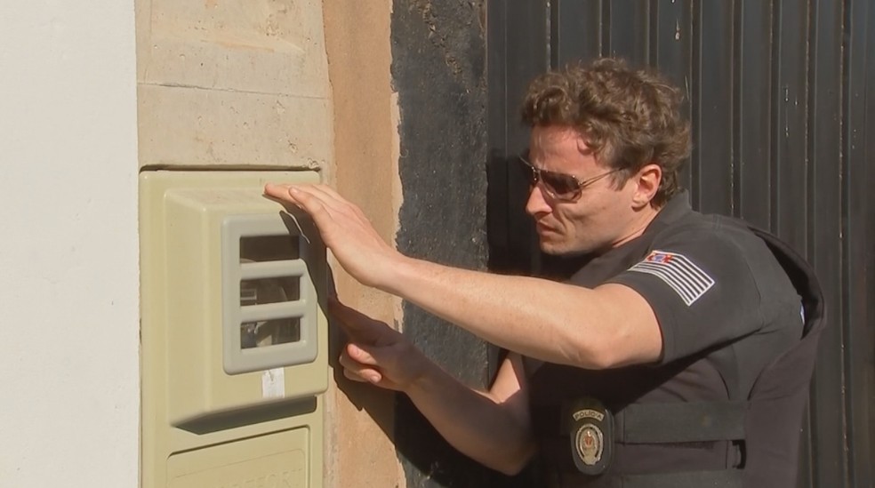 Policial fiscaliza caixa de energia em casa na região de Birigui (Foto: Reprodução/TV TEM)