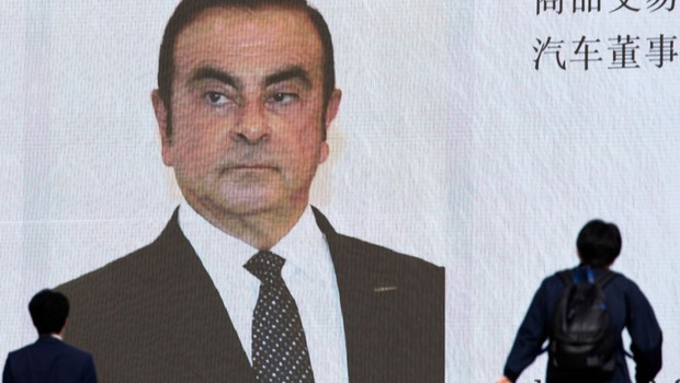 TOKYO, JAPAN - NOVEMBER 20: Pedestrians walk in front of a monitor showing an image of Nissan Motor Co. Chairman Carlos Ghosn in a news program on November 20, 2018 in Tokyo, Japan. Ghosn was detained in Tokyo on Monday over a suspected breach of Japanese (Foto: Tomohiro Ohsumi/Getty Images)