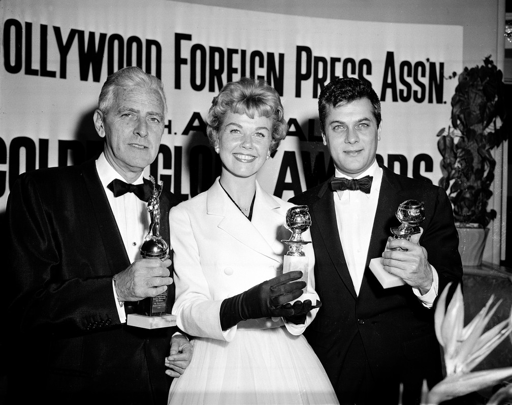 Doris Day posa ao lado de Buddy Adler (esquerda) e Tony Curtis (direita) com seus prêmios do Globo de Ouro em 1958 — Foto: Associated Press