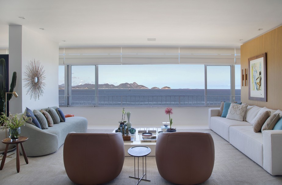 SALA DE ESTAR | O grande janelão emoldurou bem a vista para o mar. Sofá branco é da Way Design e almofadas da Paramento