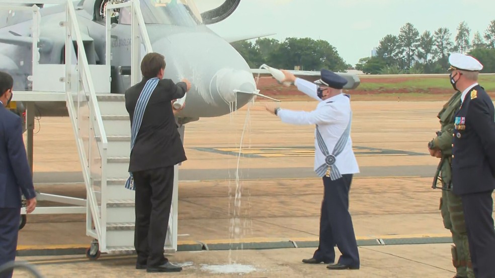 O presidente "batizou" a nova aeronave com champanhe — Foto: TV Globo/Reprodução