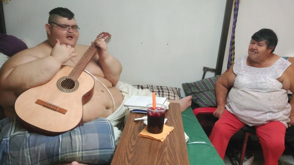 O rapaz aprendeu a tocar violão sozinho e diz que a ajuda da mãe é fundamental (Foto: BBC)