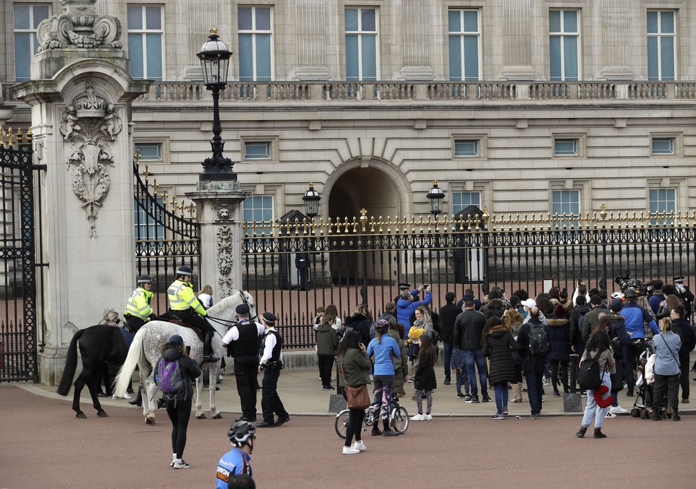 Pessoas se reúnem do lado de fora dos portões do Palácio de Buckingham, em Londres, após o anúncio sobre a morte do príncipe Philip em 9 de abril de 2021 — Foto: Matt Dunham/AP