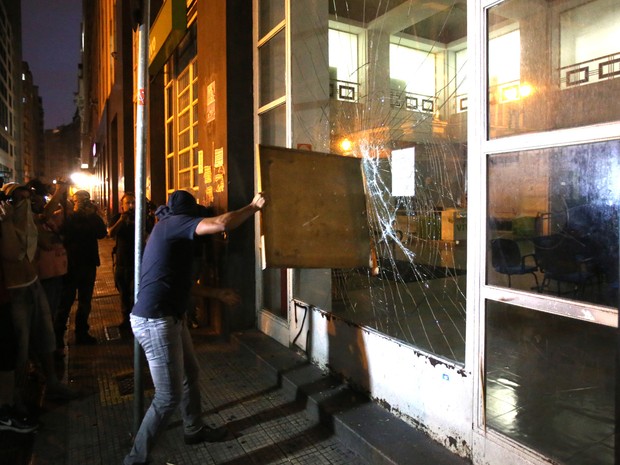 Mascarado quebra fachada de banco no centro de SP (Foto: Eduardo Anizelli/Folhapress)