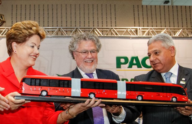Presidente recebe das mãos do Presidente do IPPUC Sérgio Pires e do Presidente da Câmara de Curitiba, Paulo Salamuni (PV), uma réplica do ônibus Ligeirão (Foto: Roberto Stuckert Filho/PR/Divulgação)