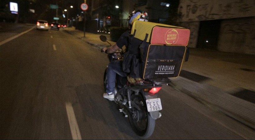 Entregador com a bolsa térmica do Delivery Reverso acoplada à bolsa do restaurante (Foto: Reprodução)